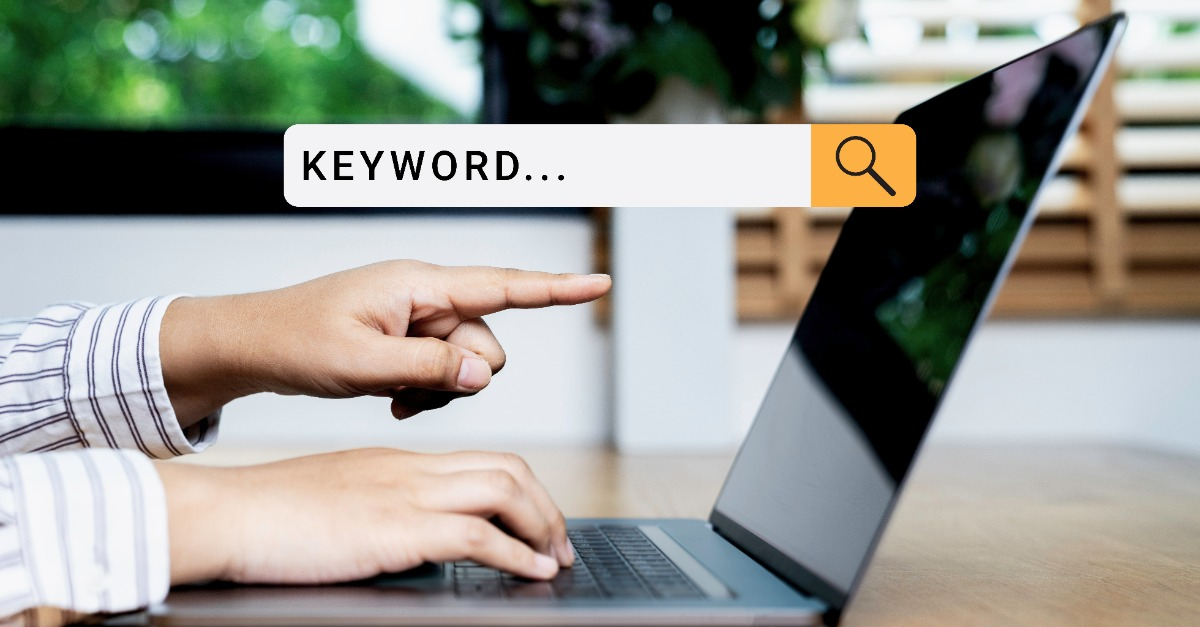 A person using a laptop to research keywords for SEO