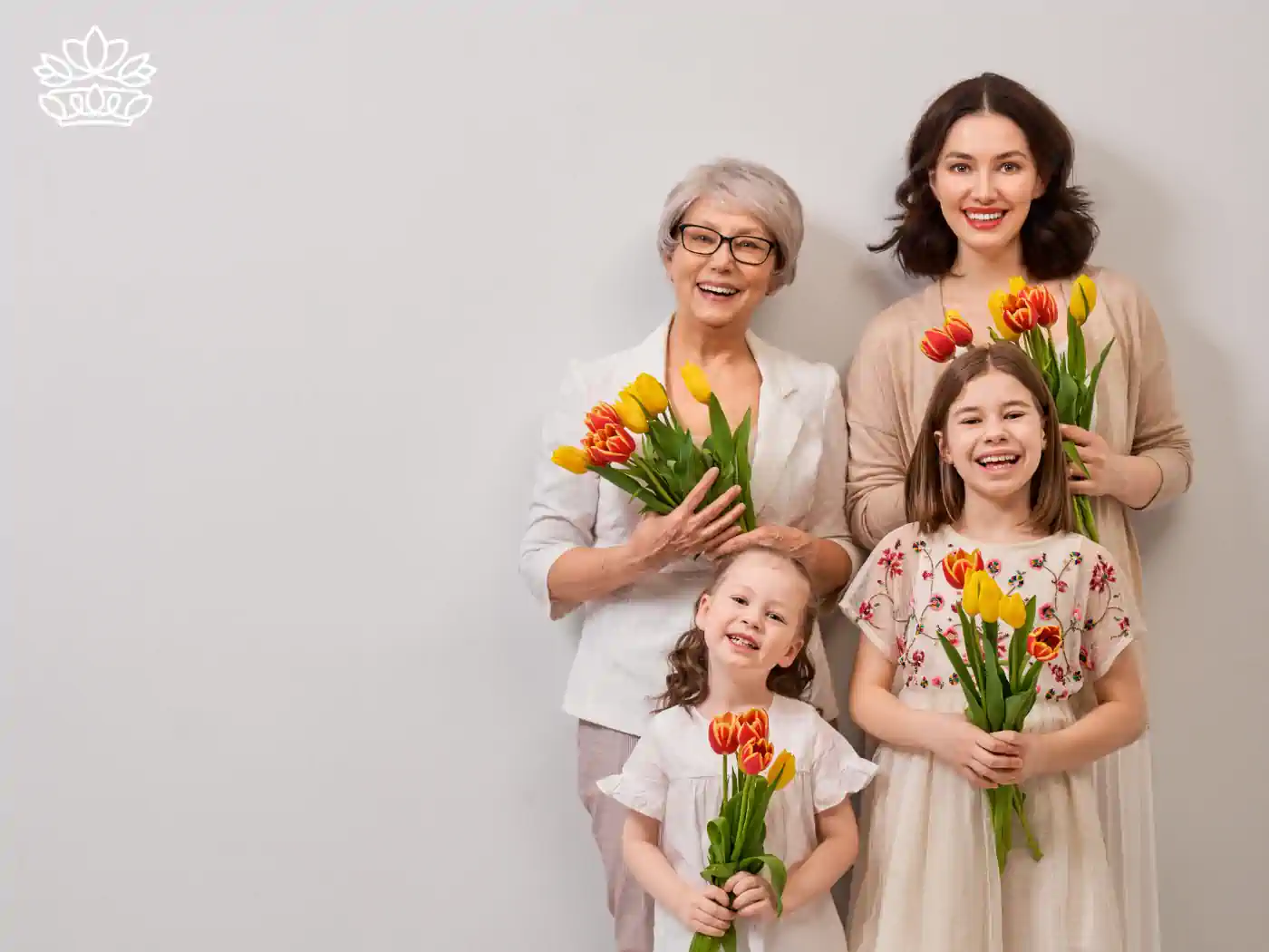 Three generations of women smiling and holding vibrant tulips. Fabulous Flowers and Gifts. Mother's Day Flowers.