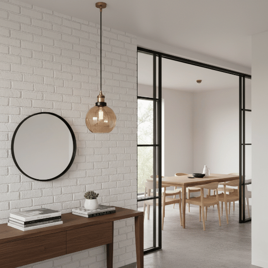 Contemporary dining room pendant light with an amber glass globe shade and warm bulb hanging near the dining area.