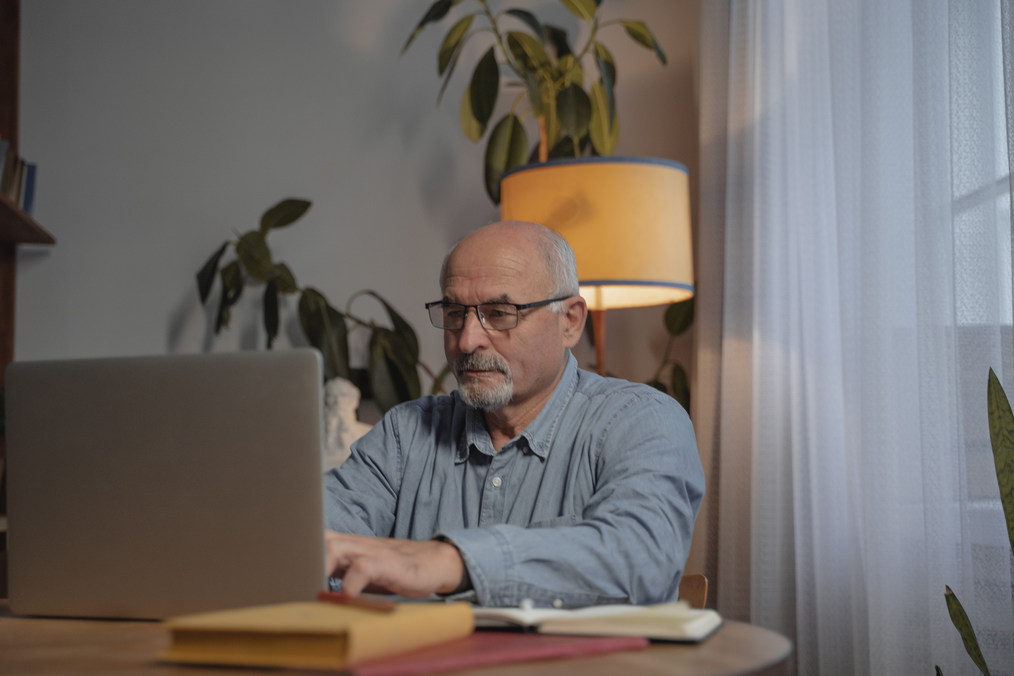 Een oudere man kijkt naar online naar zijn uitvaartverzekering.