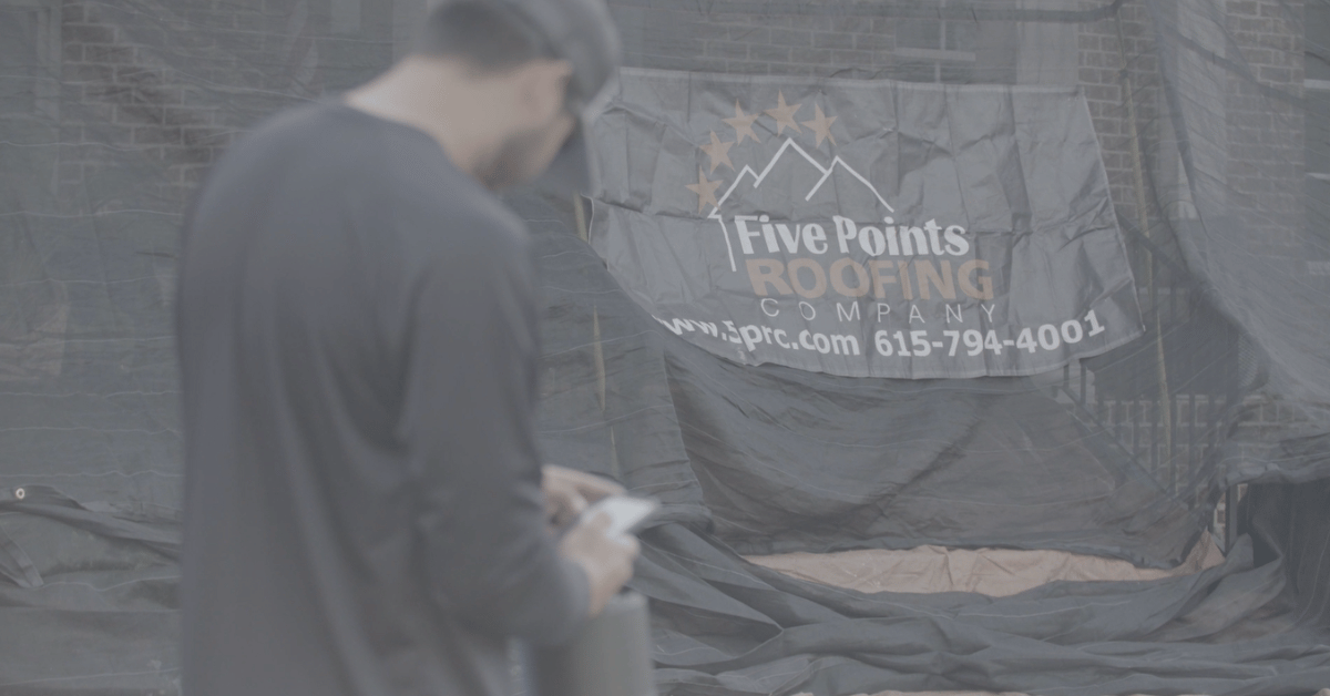 Close-up of black debris netting featuring the Five Points Roofing Company logo and contact information during a roofing project in Brentwood, TN.
