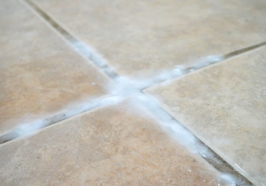 Apply baking soda paste and spray vinegar on the grout
