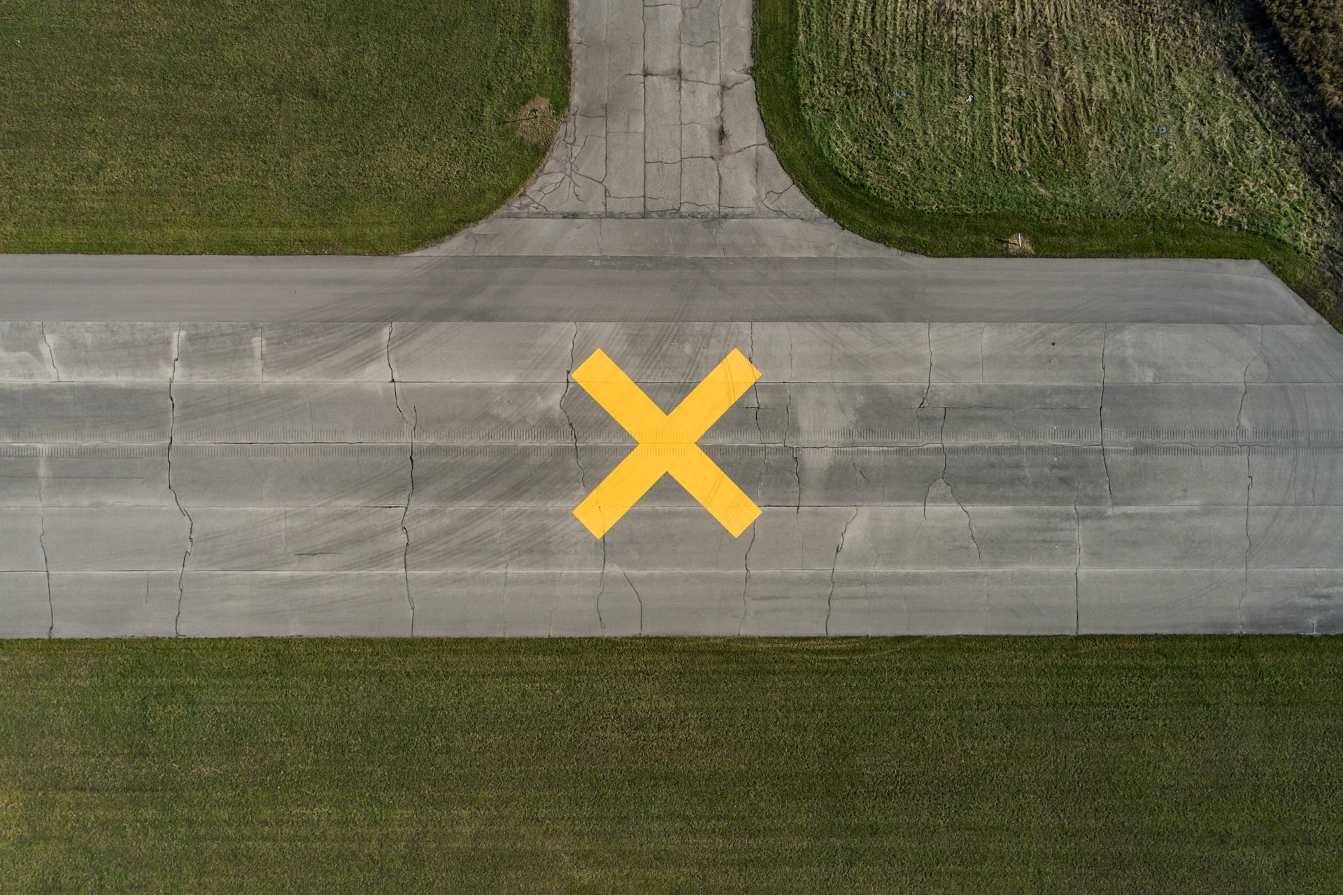 Airport sign denoting a closed runway with a yellow cross.