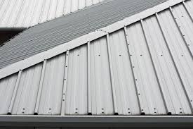 A close up of steel roof panels showing an exposed fastener roofing system.