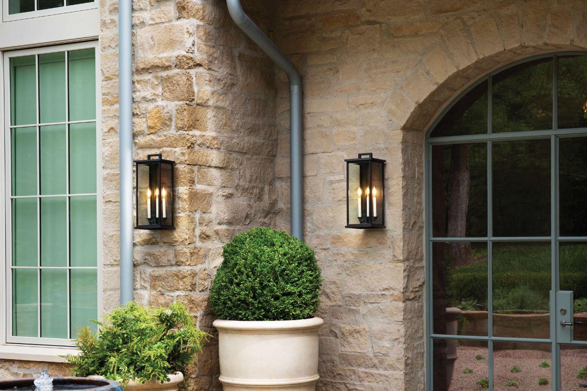 Outdoor wall light fixture ideas with black lantern style wall mounted lights on a stone exterior beside a doorway