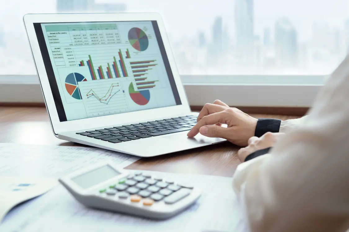 Business owner and broker reviewing recast financial reports showing steady income and clear valuation metrics.