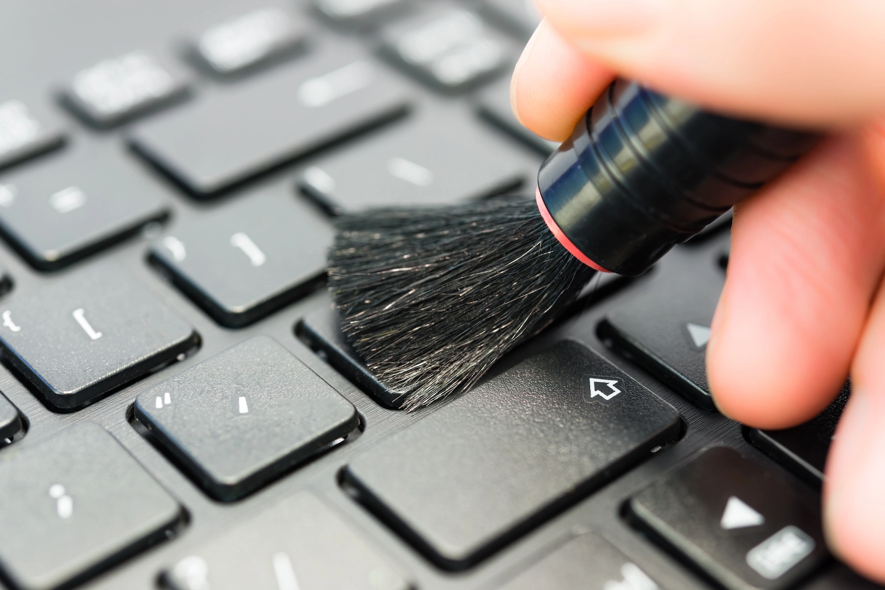 Remove filth from the laptop's keyboard keys with a keyboard brush