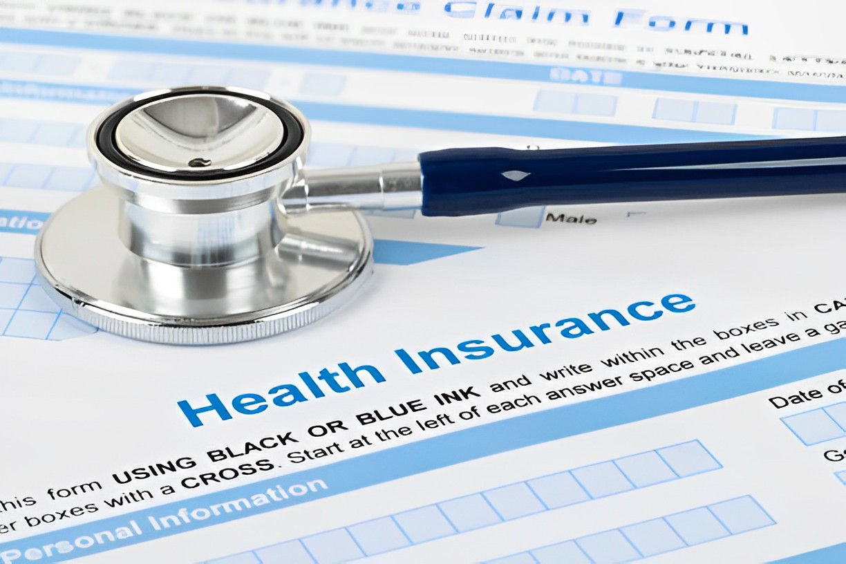 A photo of a health insurance form with stethoscope above it