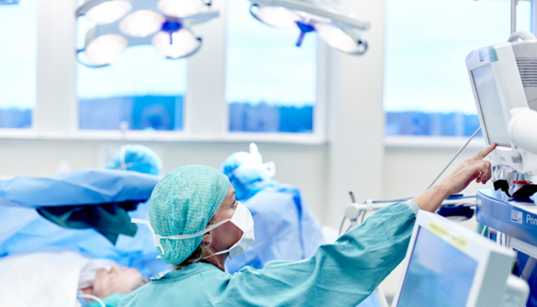 "Kirurg i operasjonssal overvåker pasientens vitale tegn på medisinsk skjerm."