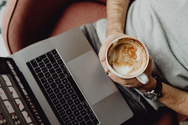 A laptop and a coffee cup, representing participating in an online creative writing course.