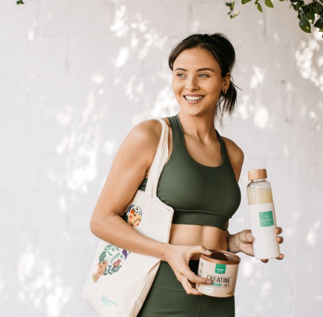 Mulher segurando Creatina Nutrify. Imagem: site oficial da marca