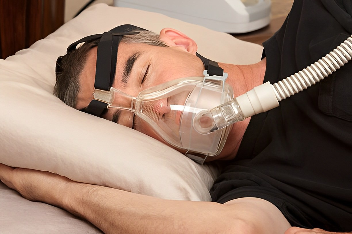 A photo of a man using CPAP while sleeping 