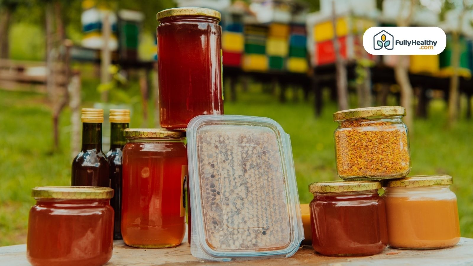 Assorted honey jars displayed outdoors near beehives