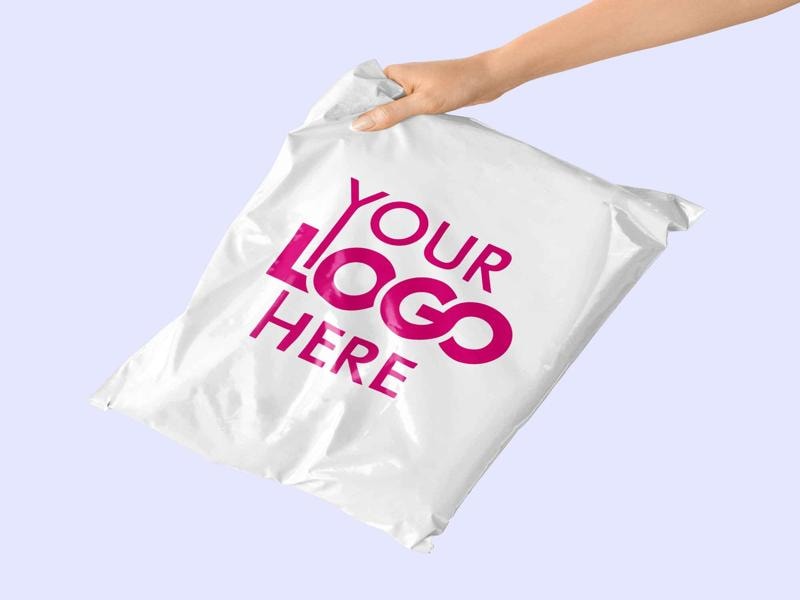A hand holding a white mailing bag with the text "YOUR LOGO HERE" printed in bold pink letters, suggesting customizable packaging for branding purposes.