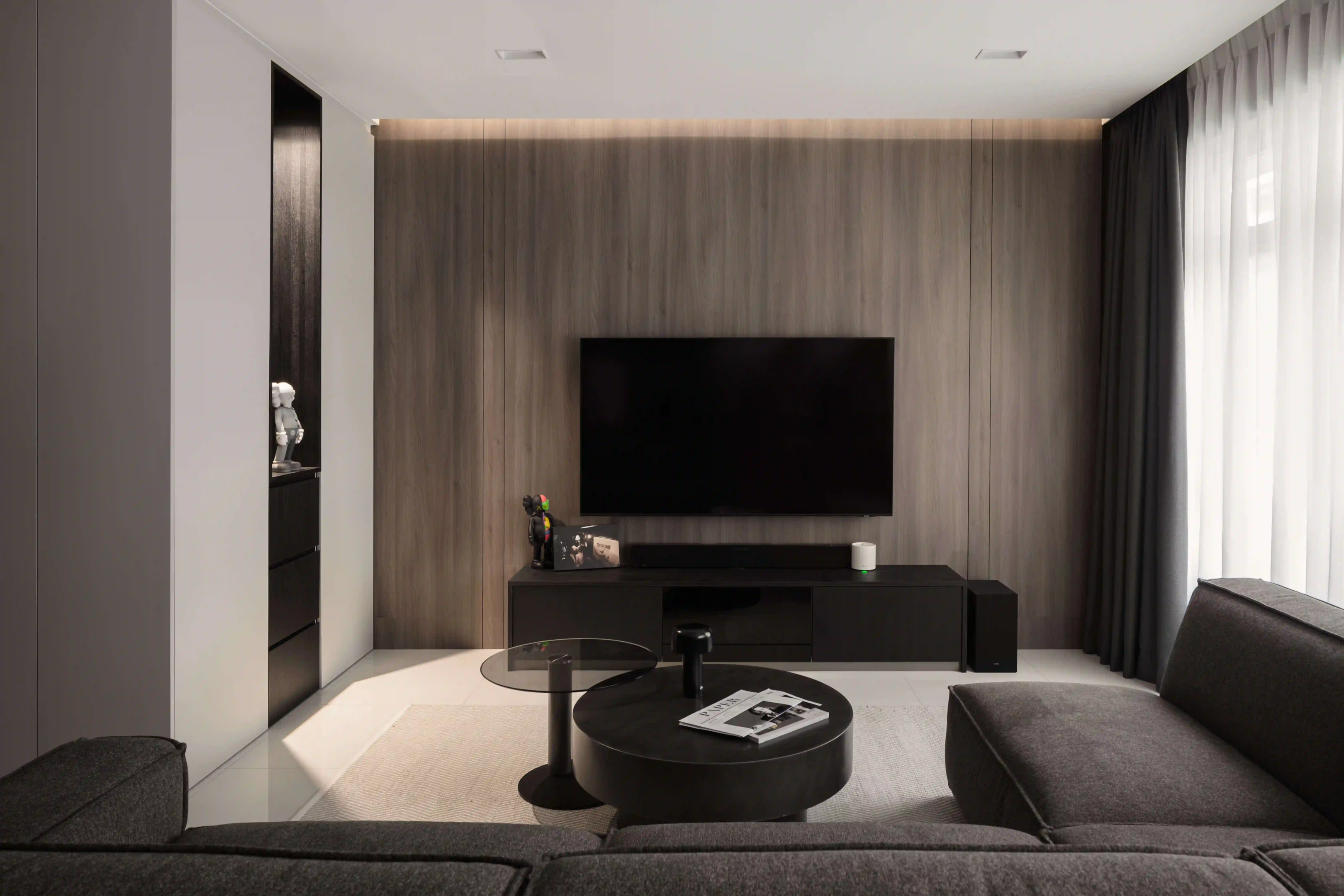 Small sitting room design with wall-mounted TV on a wood feature wall, low console and layered lighting.