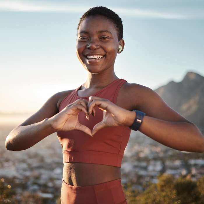 All the b vitmains - Woman making a heart shape with her hands while enjoying a hike.