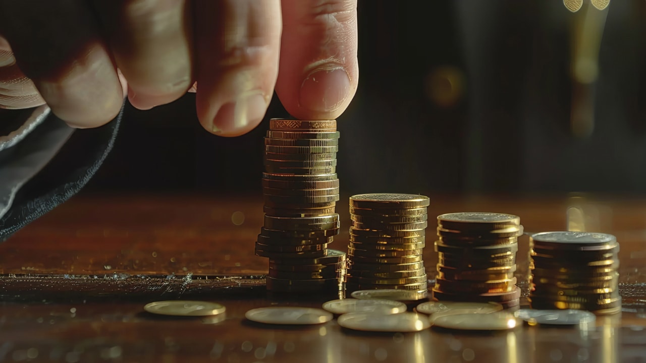 hand stacking gold coins