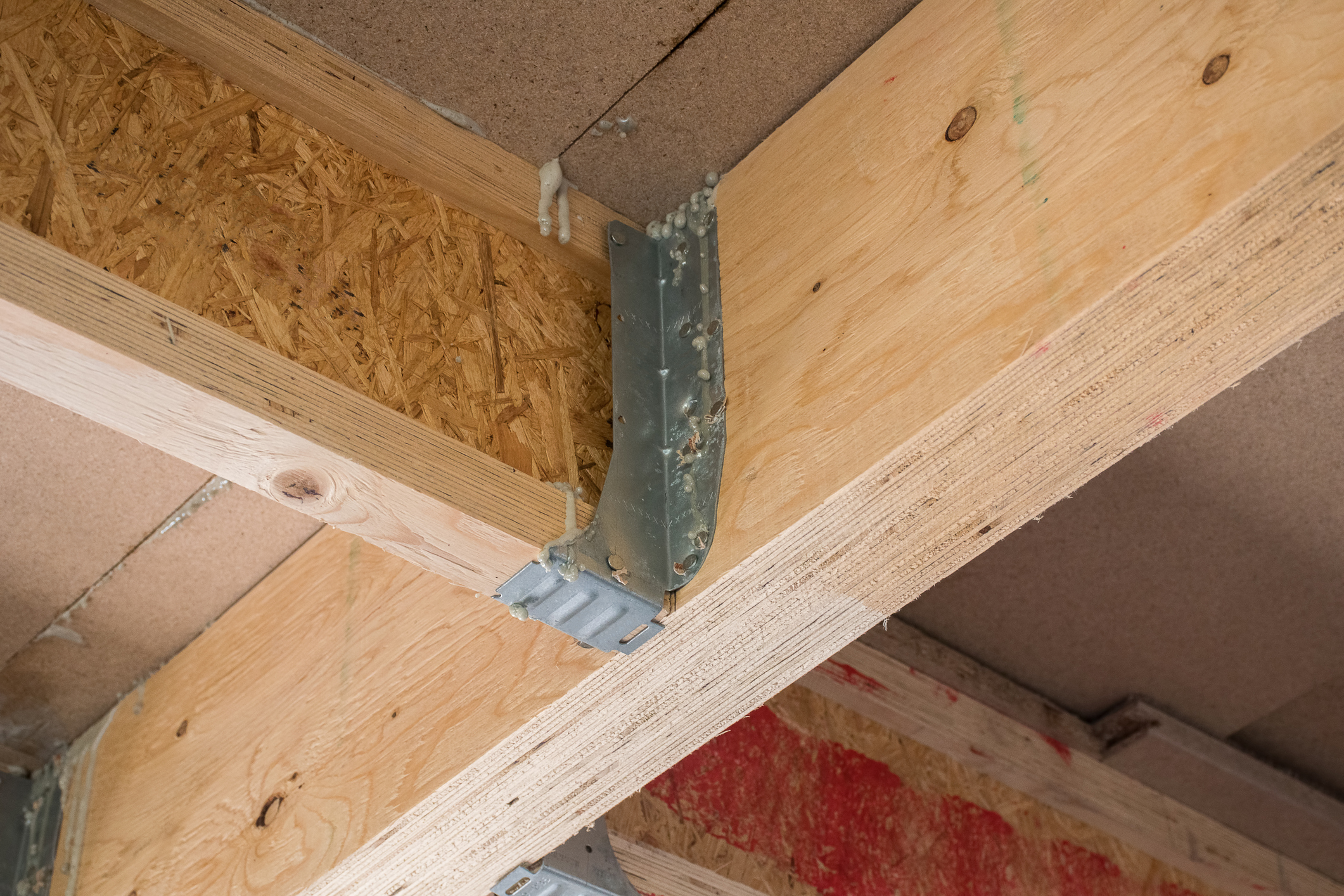 Engineered lumber beam with joist supported on steel bracket