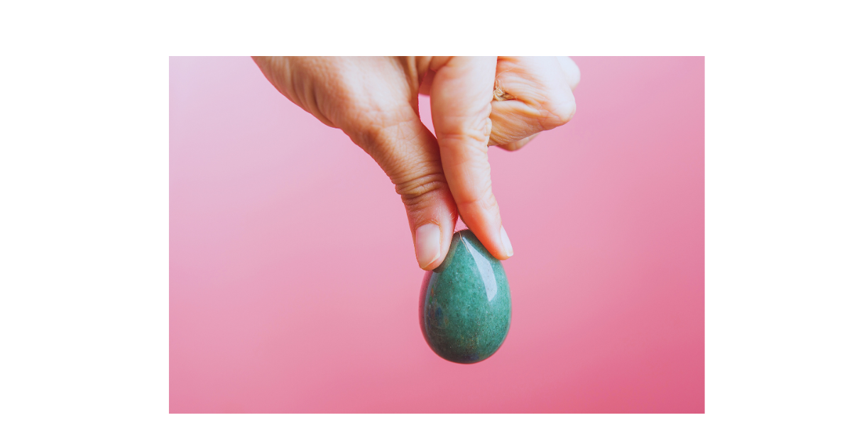 a person holding a green yoni pearl vaginal detox on a pink background