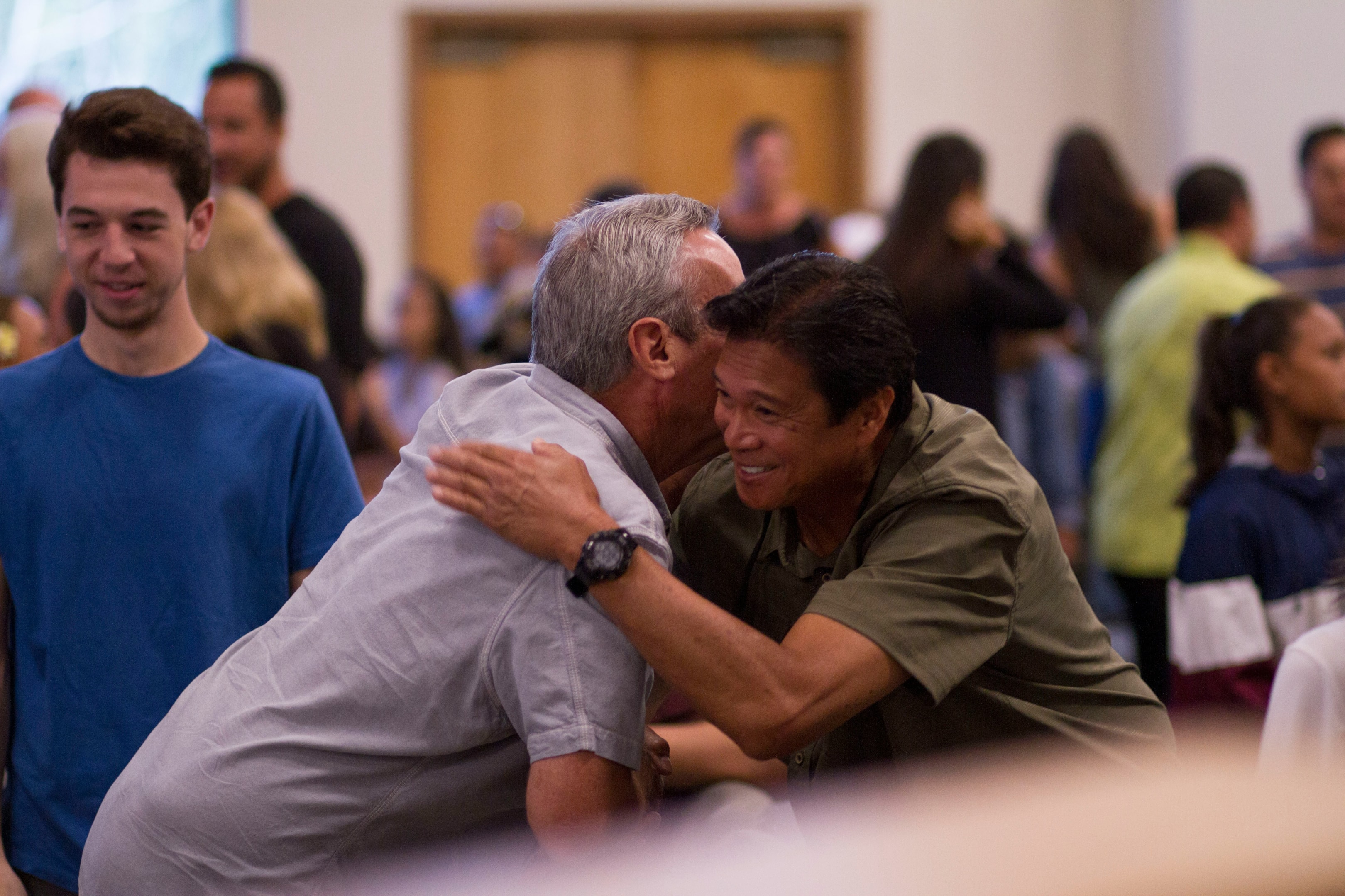 Colleagues in real estate hug at networking event.