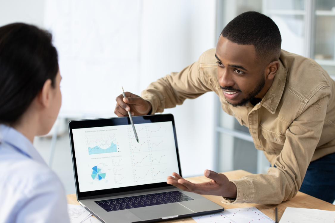 Business broker showing valuation charts on laptop to potential client