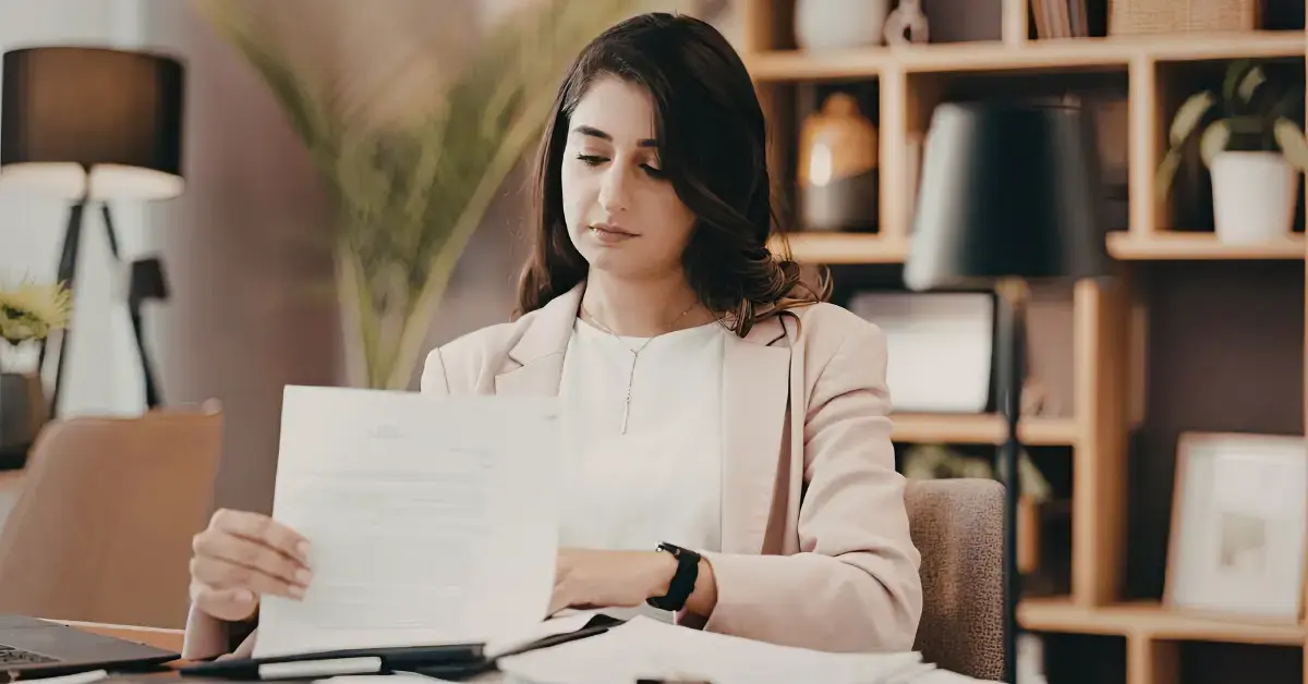 Woman reviewing IRS tax debt and a credit report while researching does IRS collections go on credit report.