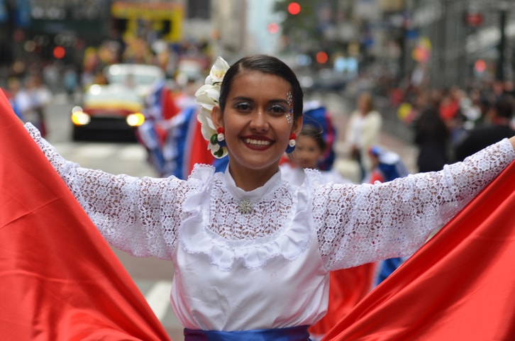 Beautiful Hispanic young woman marching in a parade. 