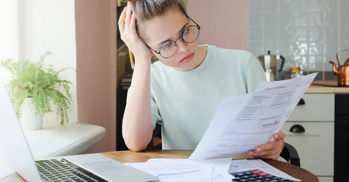 Woman reviewing tax debt and IRS documents for an offer in compromise application.