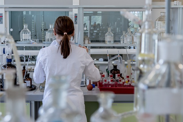 An image of a woman wearing a white lab coat and working in a laboratory.