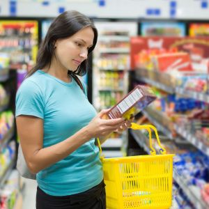 woman reading food label on baked goods to find how many grams of sugar are added
