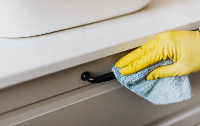 cleaning dust off a cabinet 