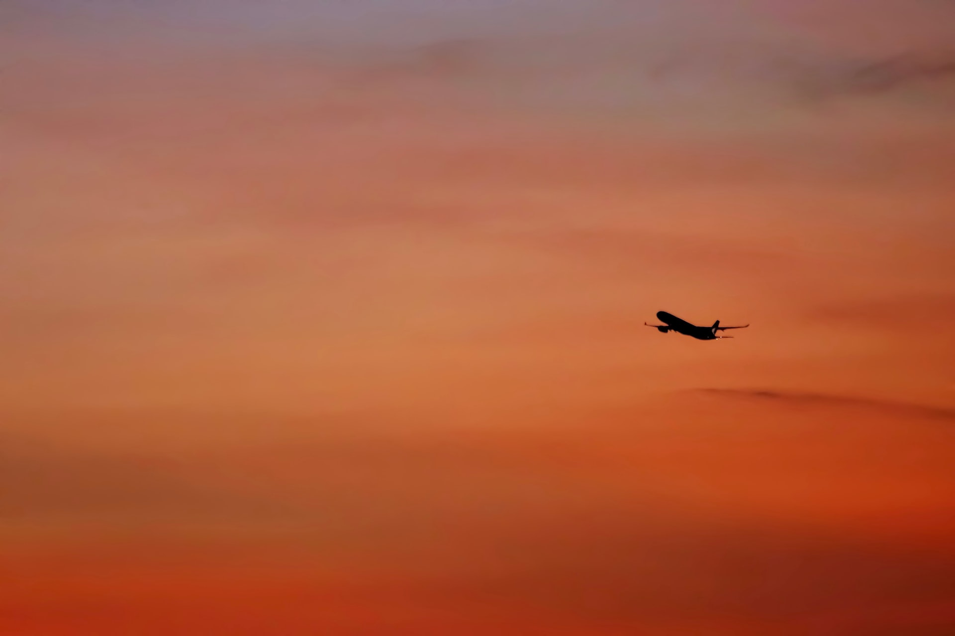 An aircraft taking off in an evening sky. How long does it take to fly around the world?