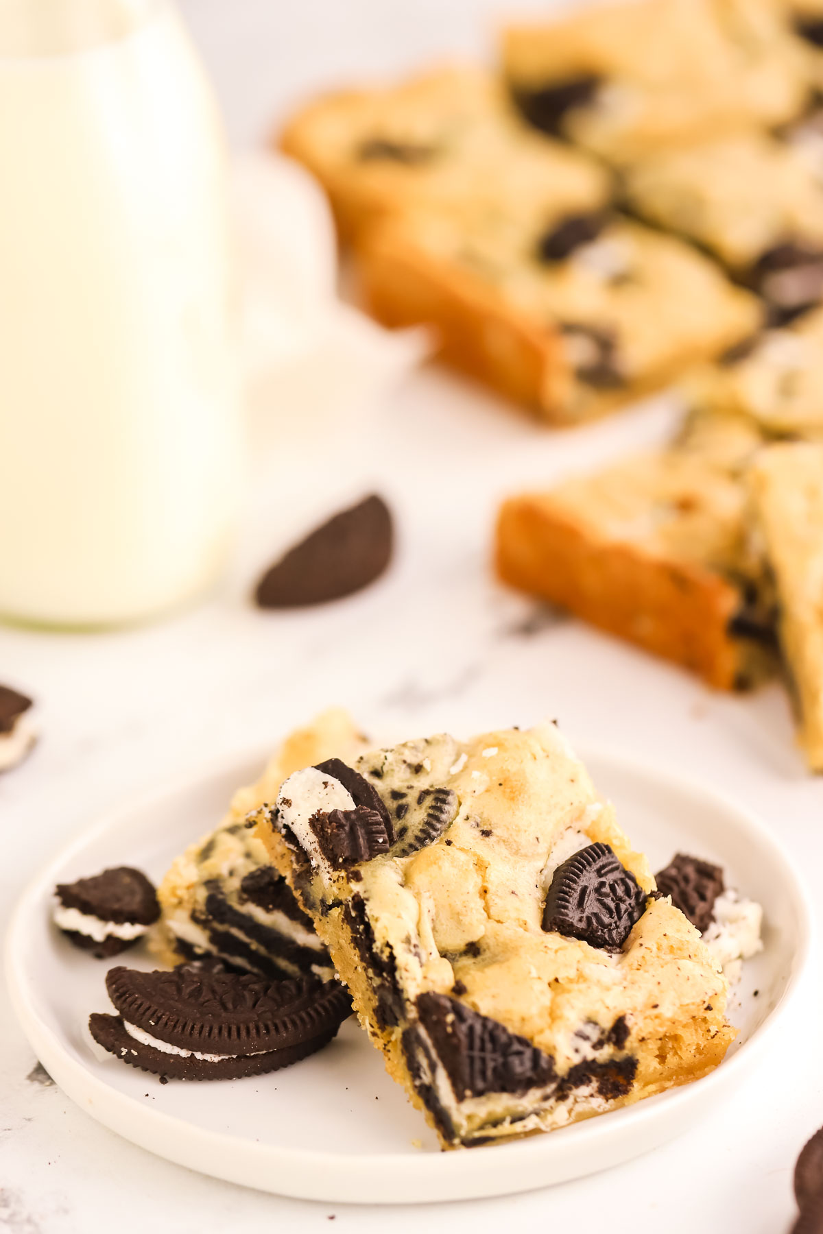 two Oreo blondies, and Oreo cookies on a white plate