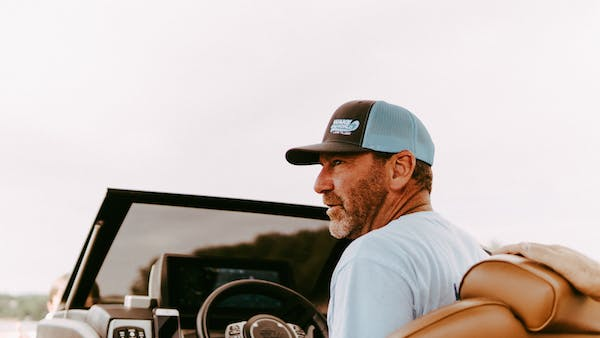 man wearing a baseball cap while driving
