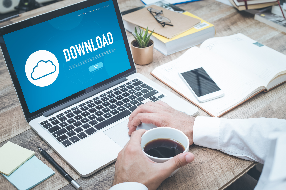 Business user reviewing downloadable broker case studies and marketing files on a laptop