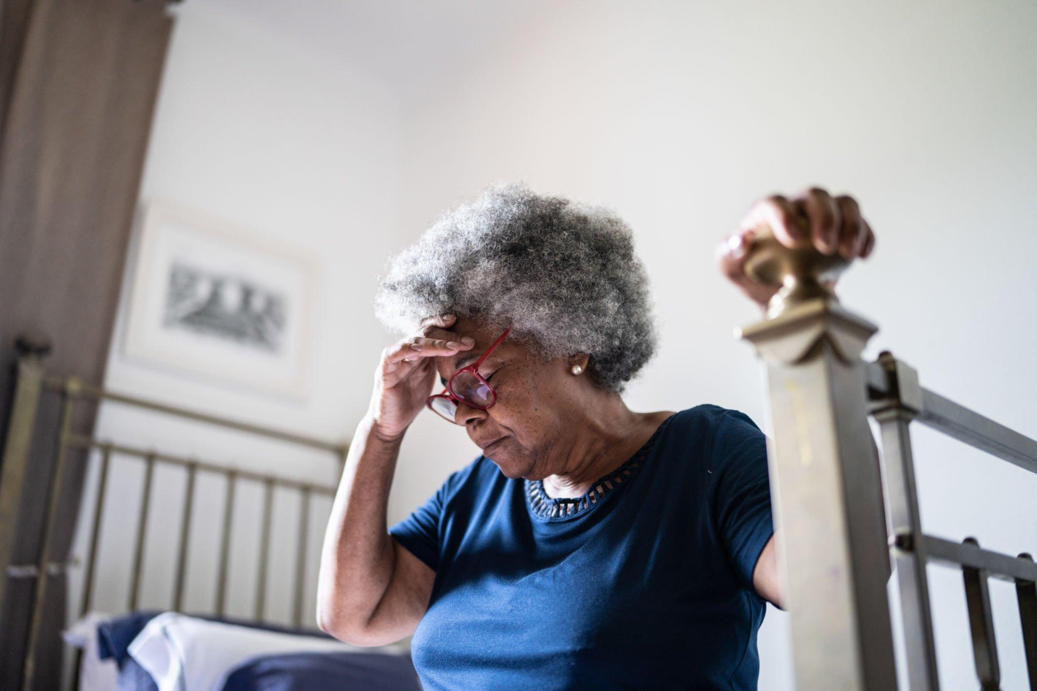 A woman experiencing a headache, while considering the role of insulin-producing cells and their connection to digestive and kidney diseases.