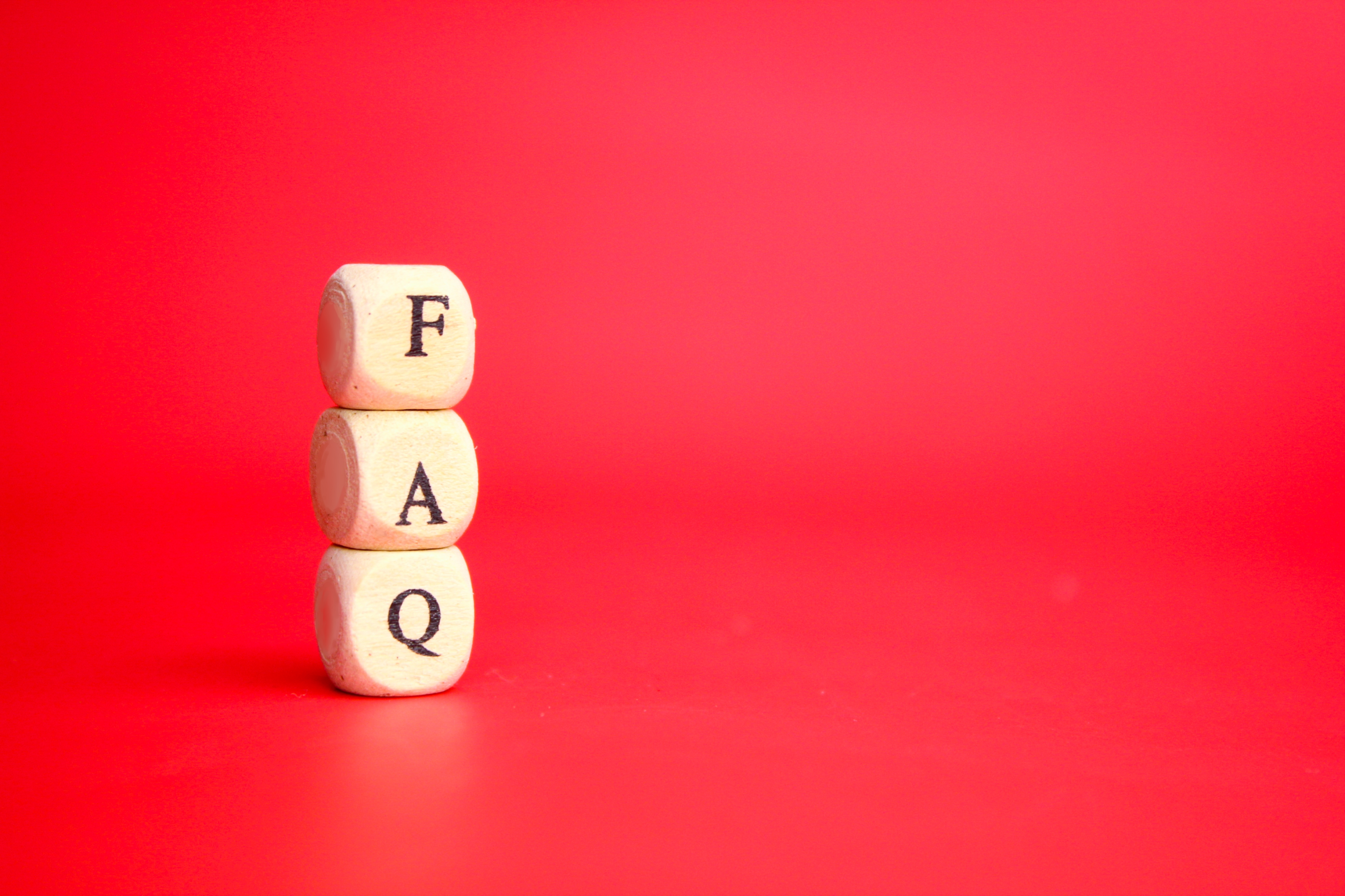 "Wooden cube displaying 'FAQ' – delving into frequently asked questions."