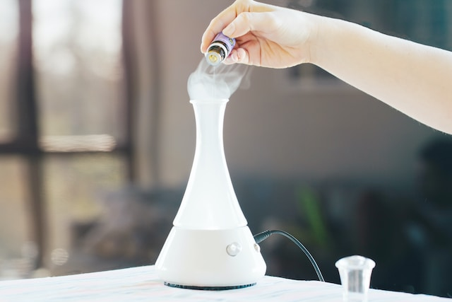Hand Putting Essential Oils In A Diffuser