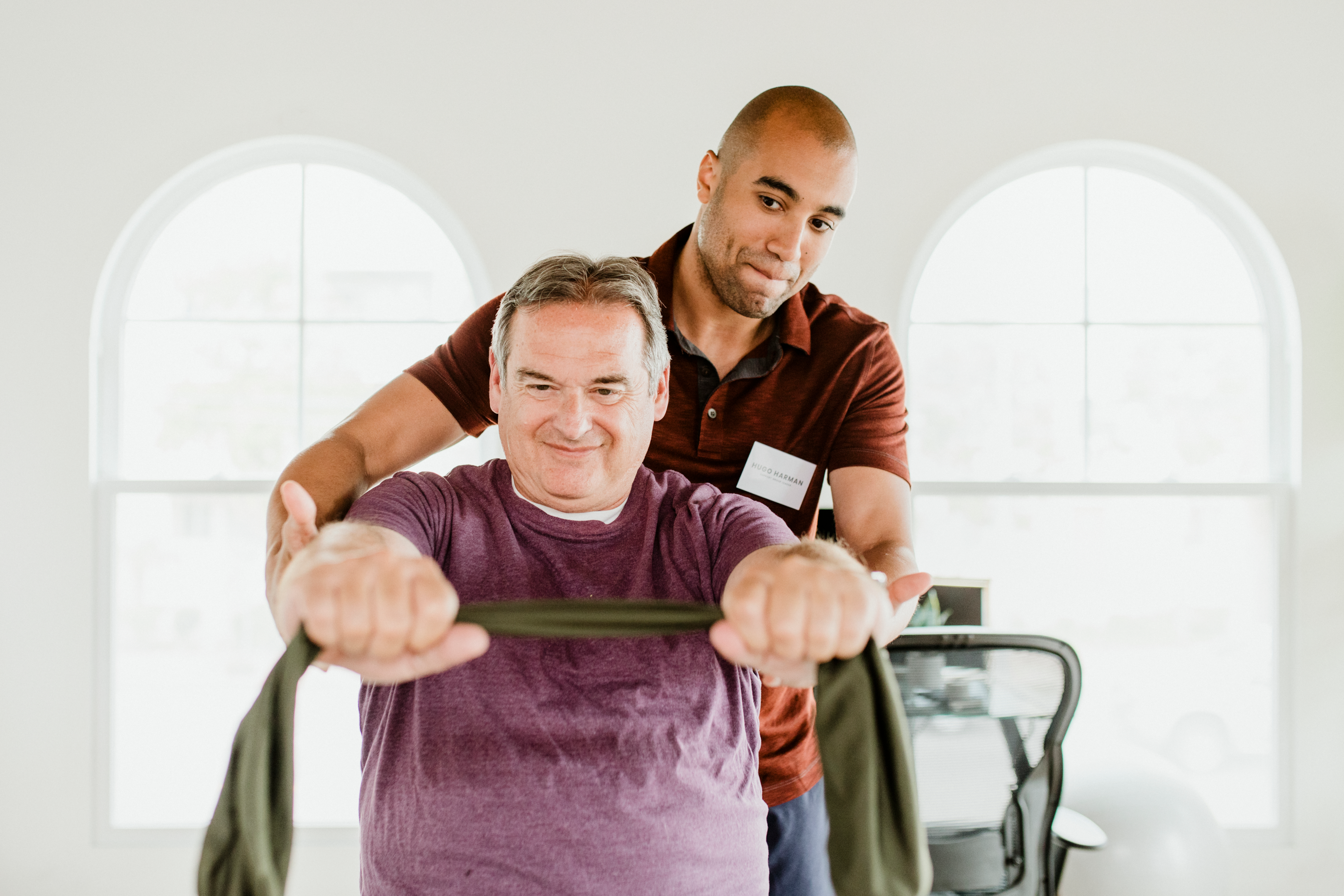 Image of a physical therapist assisting a balance challenged client in walking with assistive devices.