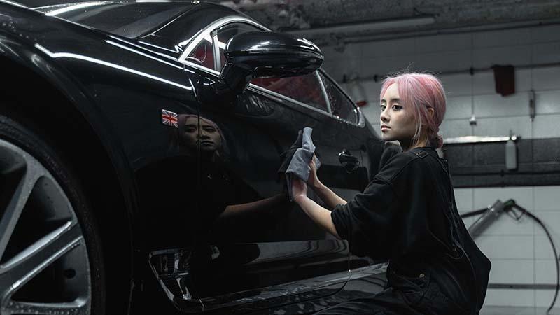 Woman drying a black car