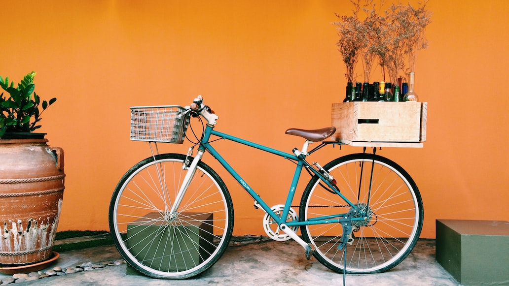 Bicicleta com cesto e caixa na carona - Unsplash