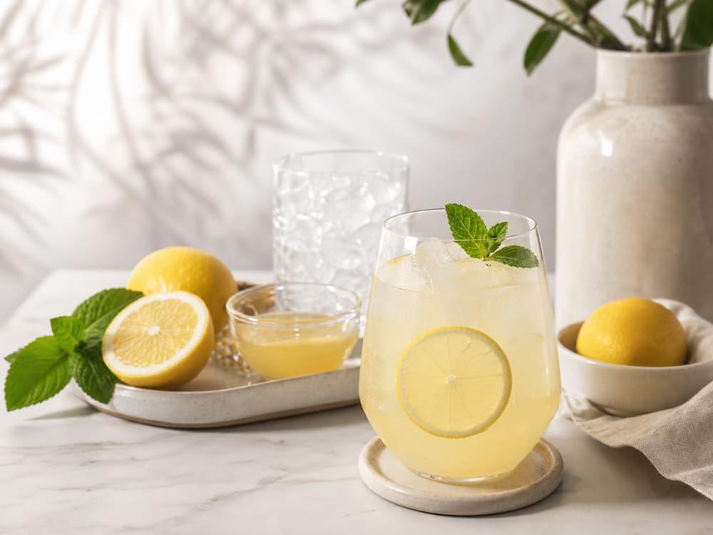 Alcohol-free lemon spritz with lemon syrup, sparkling water, mint, and lemons.