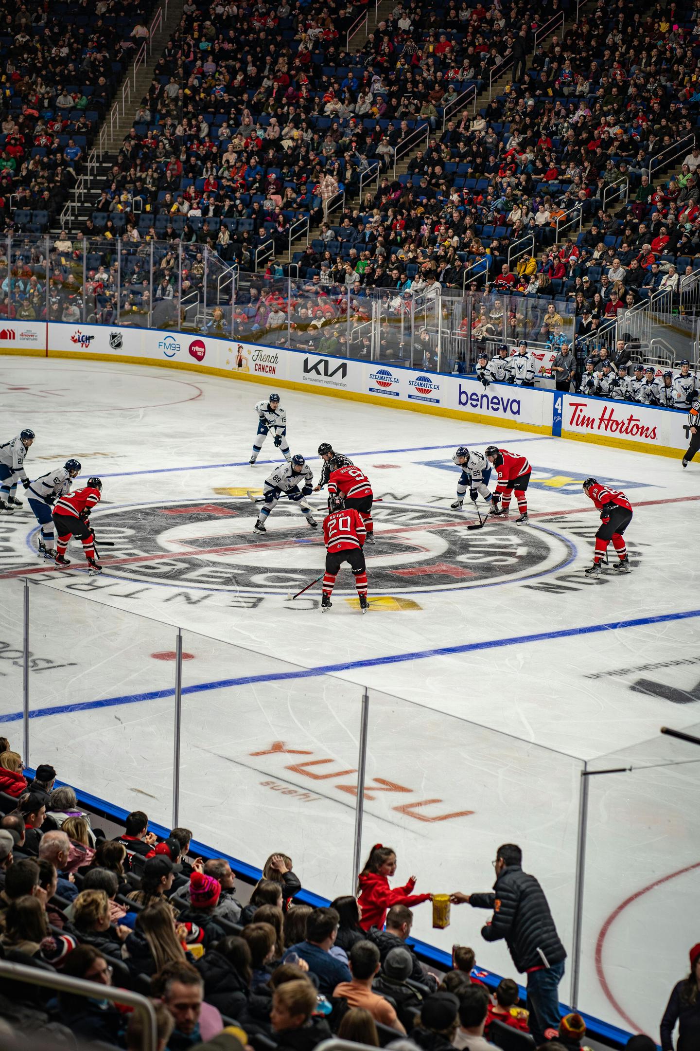 hockey players on the ice with dasher board ads and ice surface ads