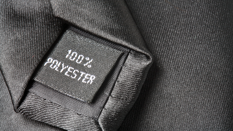 A black tag on a black tie reads "100% POLYESTER".
