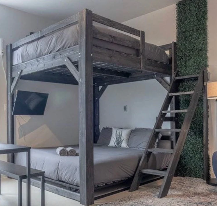 large grey wooden loft bed with bed underneath