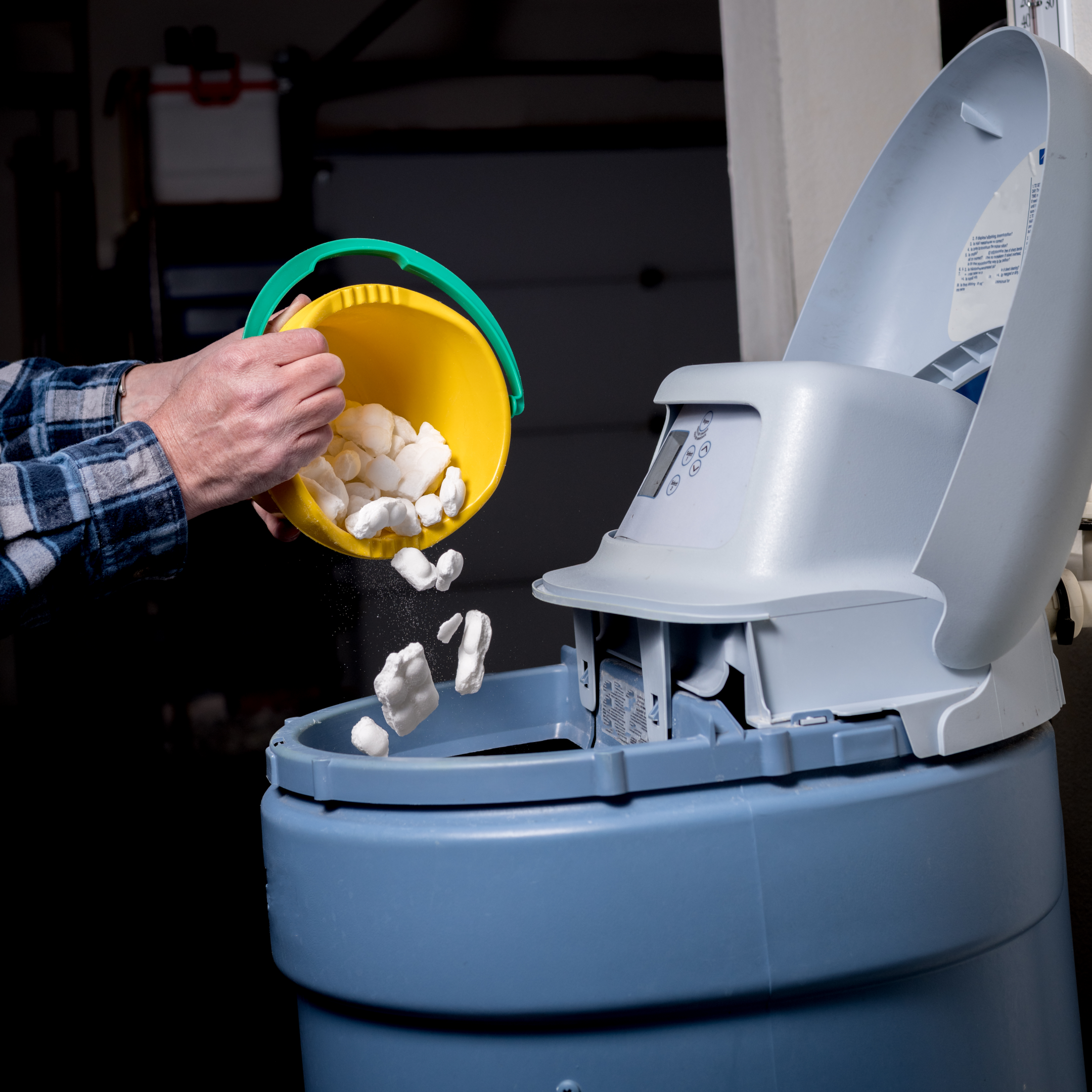 A person cleaning a water softener system
