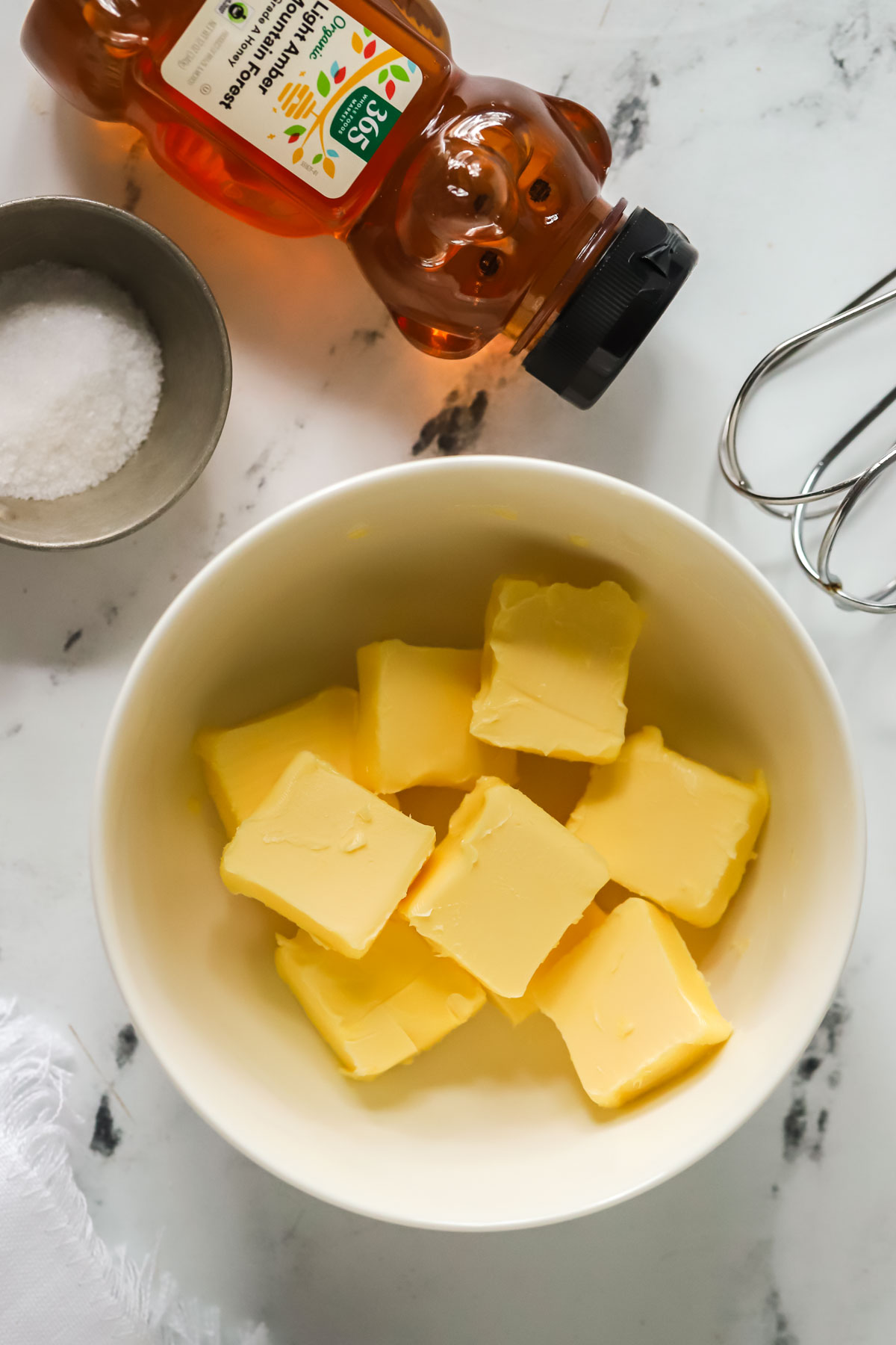 bowl of cubed butter, a honey bear, and a dish of salt