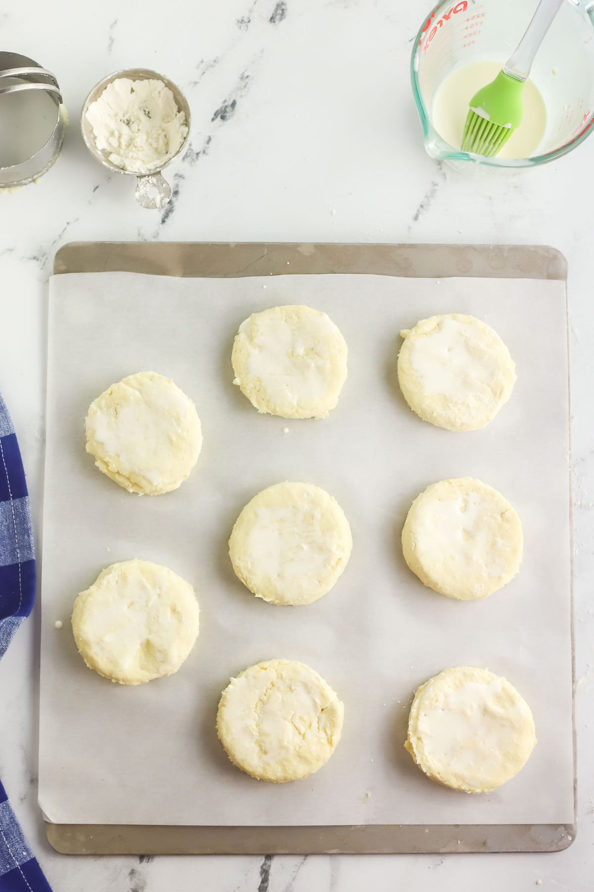 unbaked cream biscuits on a parchment lined baking sheet