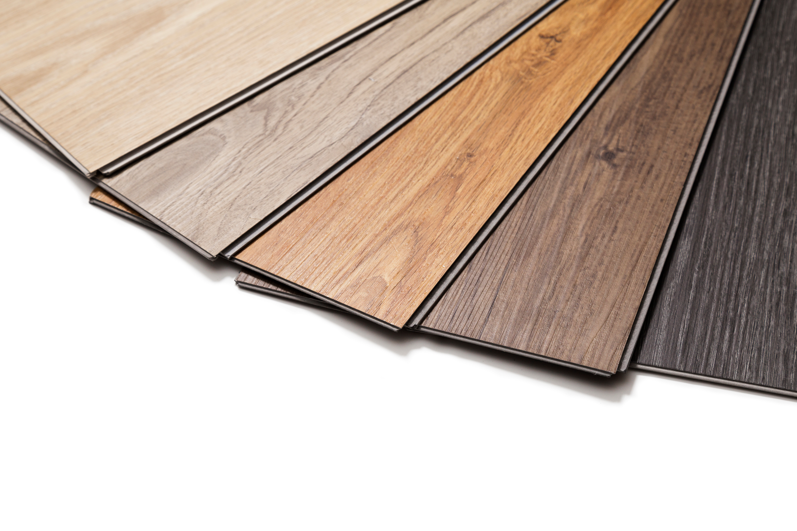 A collection of seven Laminate flooring planks arranged in a fan shape, displaying a gradient of colors from light beige to dark brown on a white background.