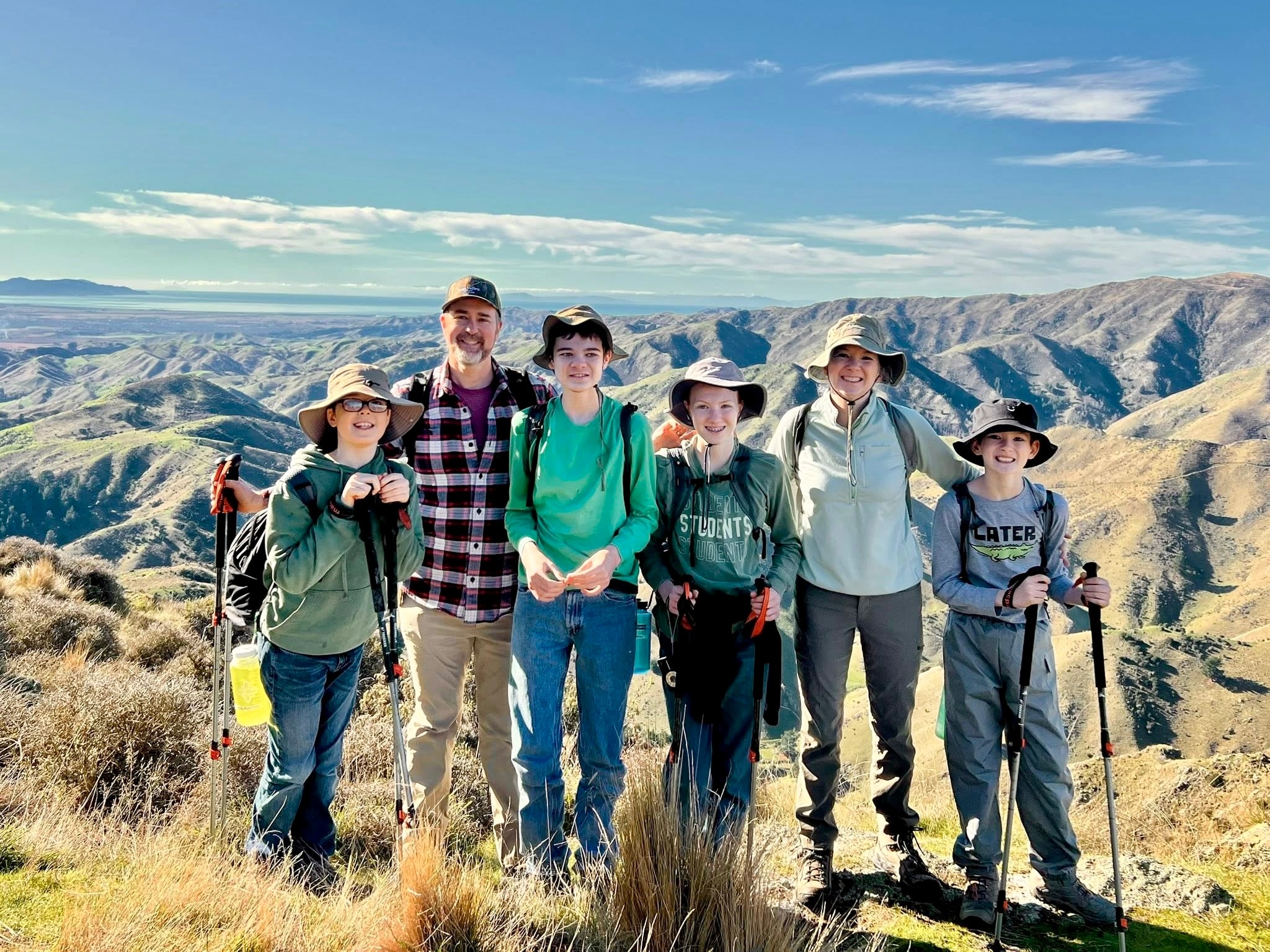 Family enjoying outdoor adventure in New Zealand surrounded by stunning natural landscapes.